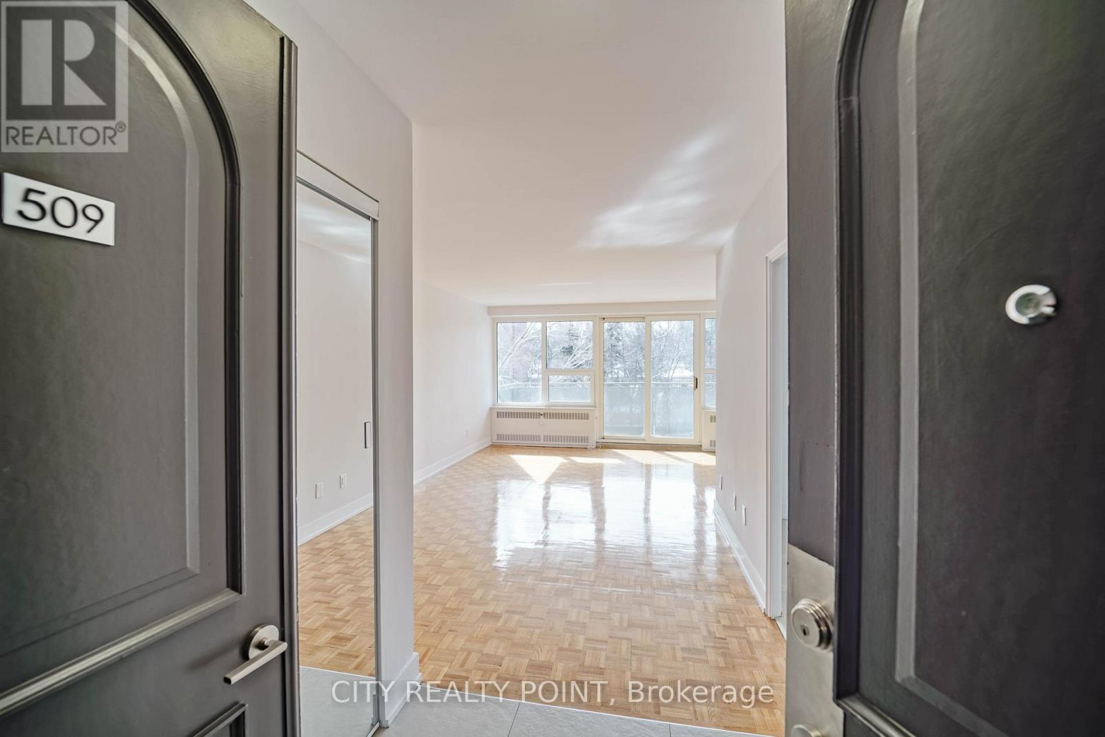 A hallway with a door on the left and a window on the right.