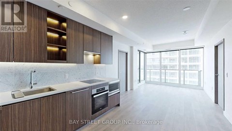 A modern kitchen with wooden cabinets and a marble countertop.