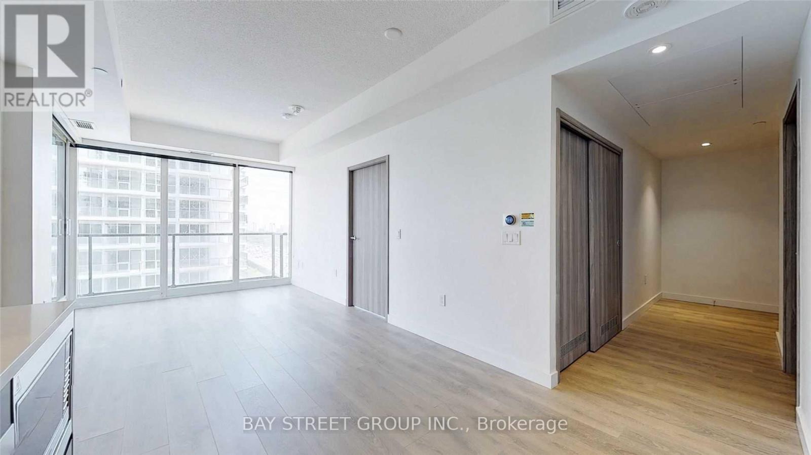 A spacious room with a view of a building outside the window.