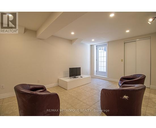 A living room with a brown leather chair and a flat screen TV.