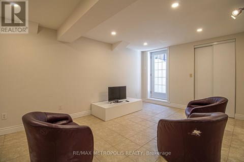 A living room with a brown leather chair and a flat screen TV.