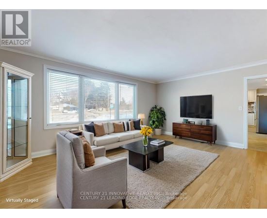 A living room with a grey couch, a coffee table, and a flat screen TV.