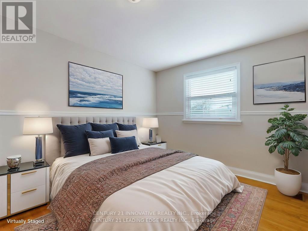 A bedroom with a large bed and a potted plant.