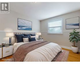 A bedroom with a large bed and a potted plant.