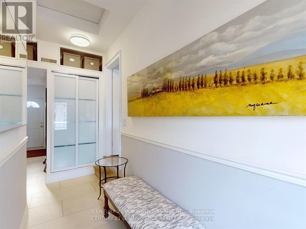 A painting of a field with trees is on the wall above a bench in a hallway.