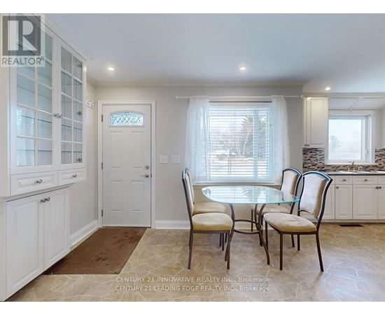 A dining room with a table and chairs.