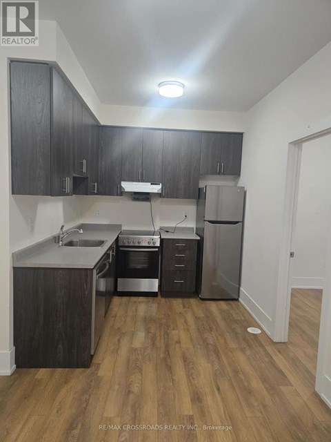 A kitchen with wooden cabinets and a stainless steel refrigerator.