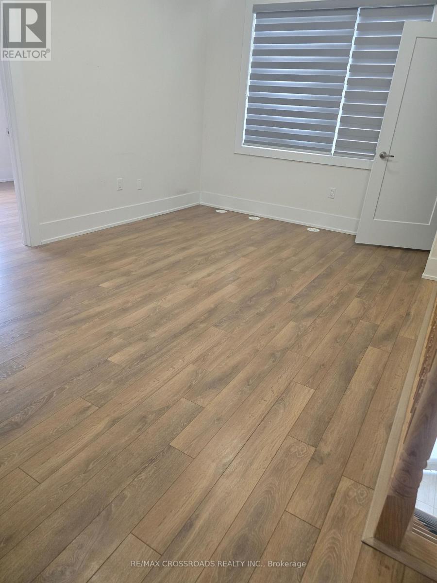 A room with wooden flooring and a window with blinds.