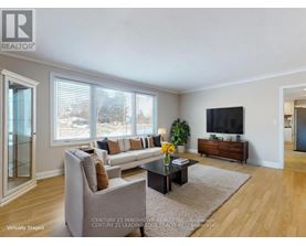 A living room with a grey couch, a coffee table, and a flat screen TV.