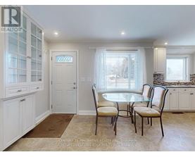 A dining room with a table and chairs.