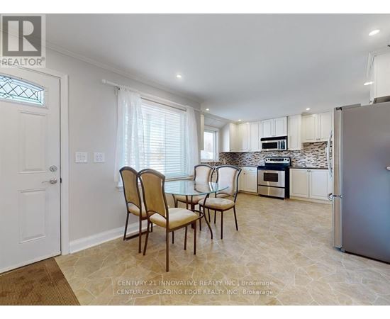 A kitchen with a table and chairs in front of a refrigerator.