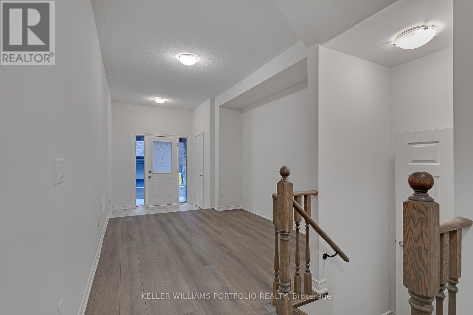 A spacious room with a staircase leading to the second floor.