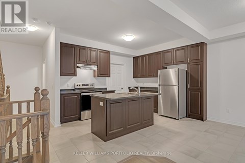 A kitchen with brown cabinets and a stainless steel refrigerator.