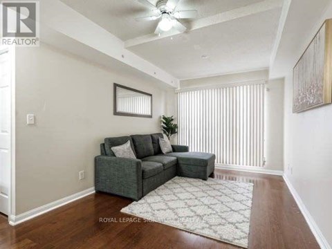 A living room with a grey couch and a rug.