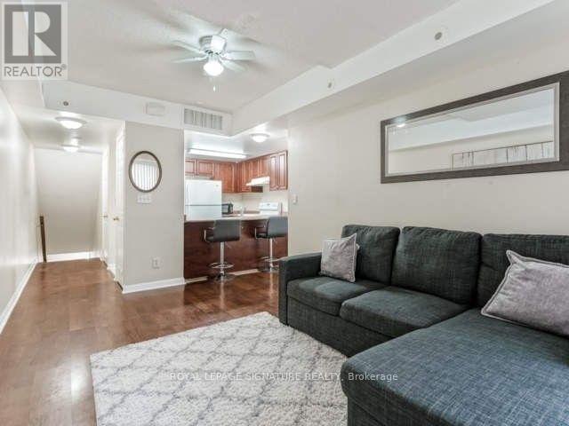 A living room with a grey couch and a bar area in the background.