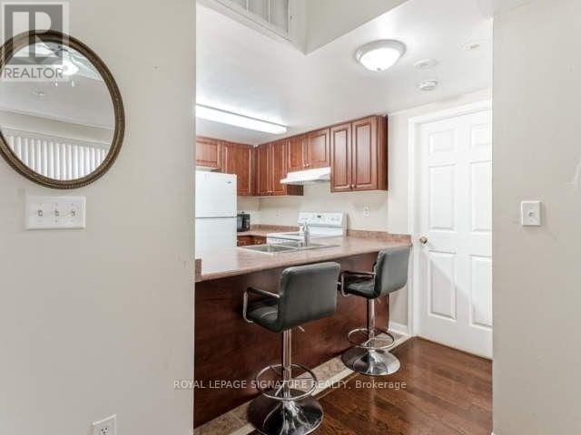 A kitchen with brown cabinets and a white fridge.