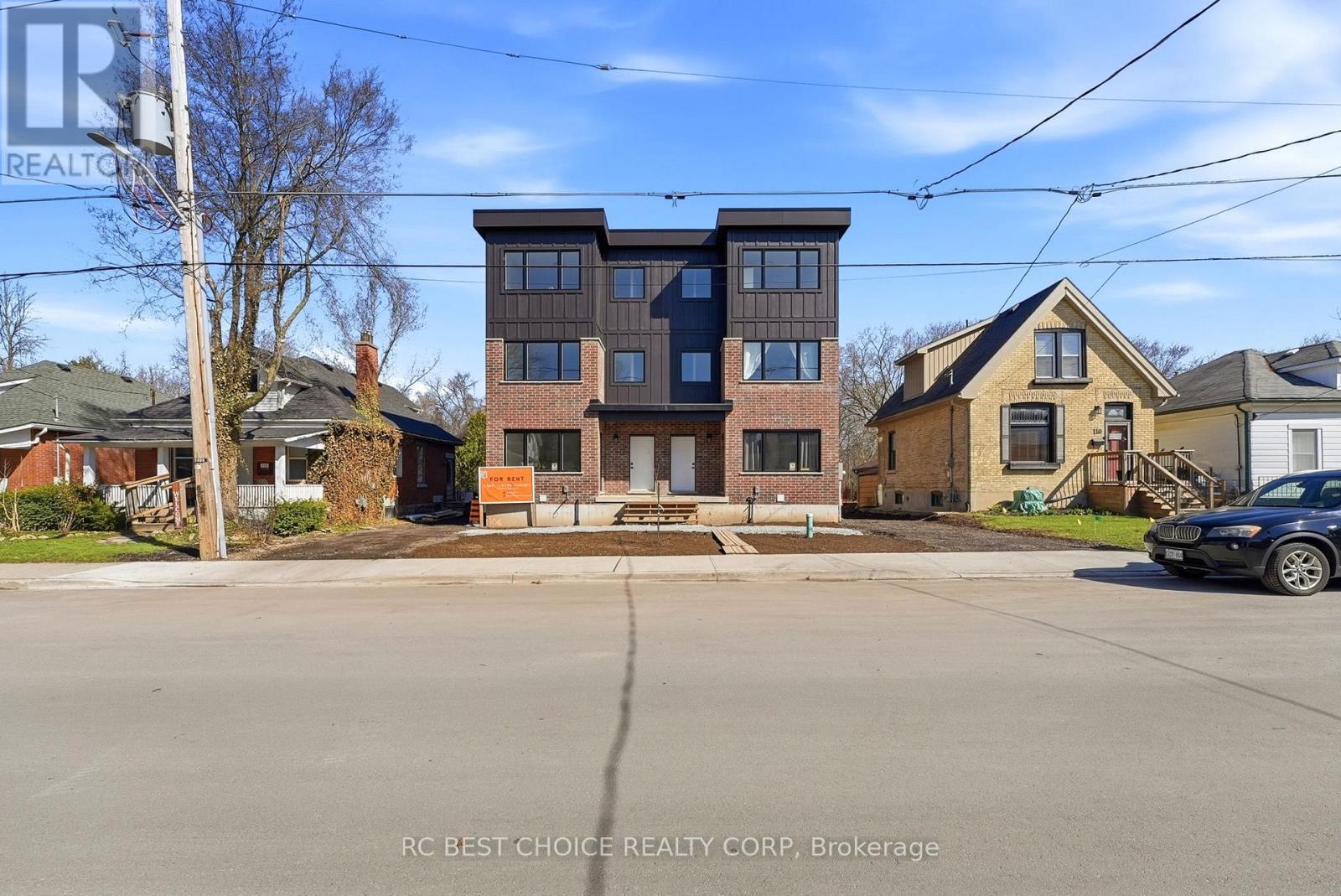 A multi-story building with a car parked in front of it.