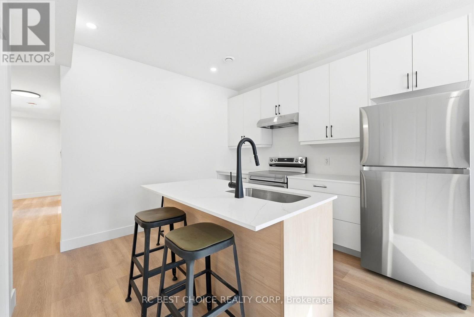 A kitchen with white cabinets and a white island with a sink.