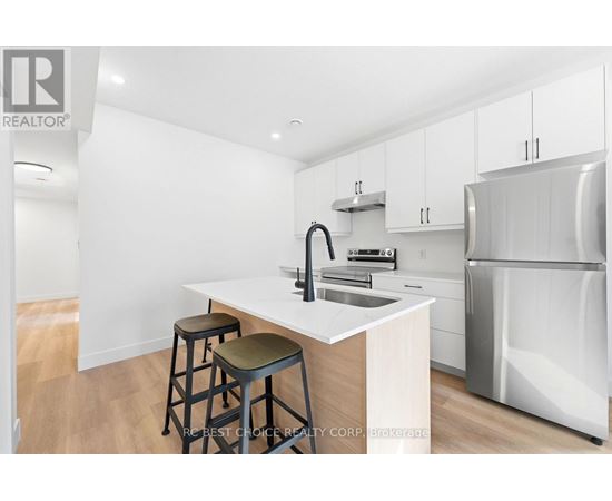 A kitchen with white cabinets and a white island with a sink.