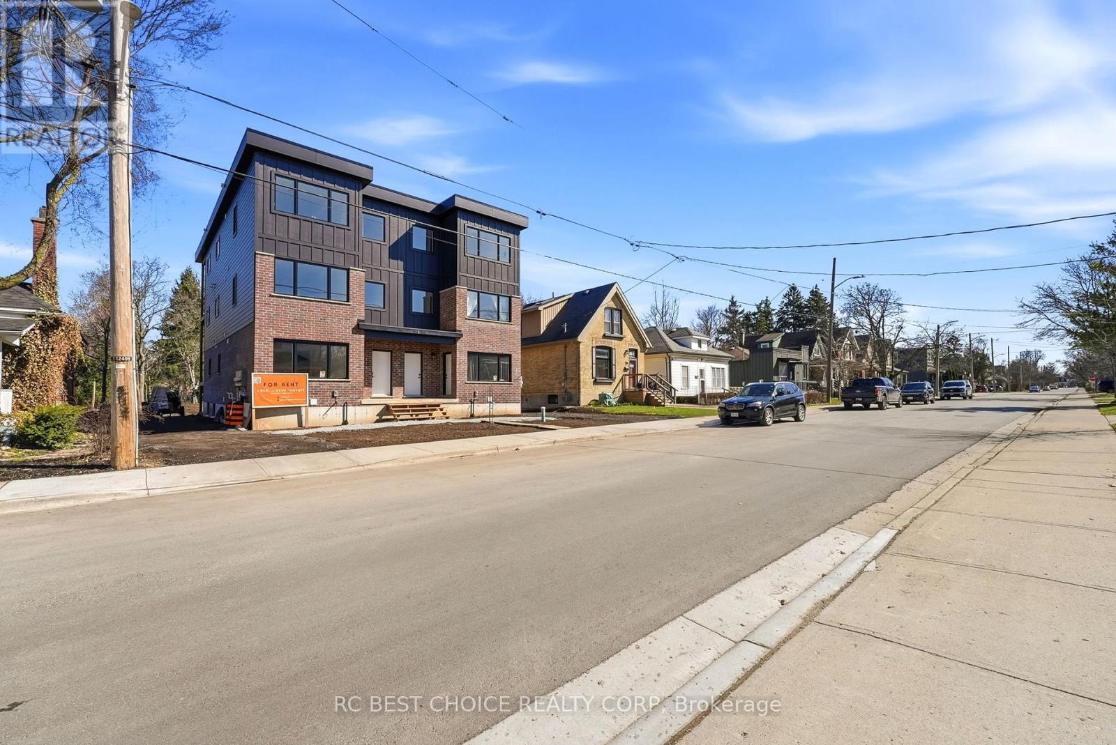 A street view of a residential area with houses and cars.