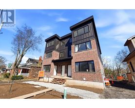 A modern house with a brick facade and large windows is for sale.