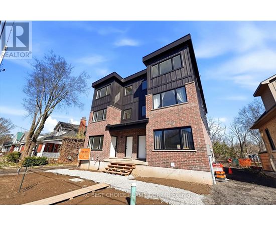 A modern house with a brick facade and large windows is for sale.