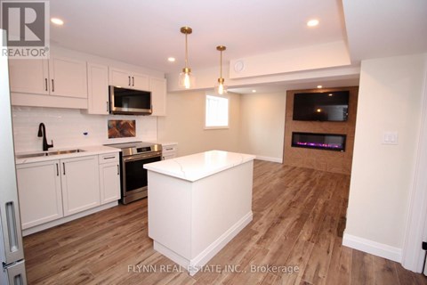 A kitchen with white cabinets and a white island.