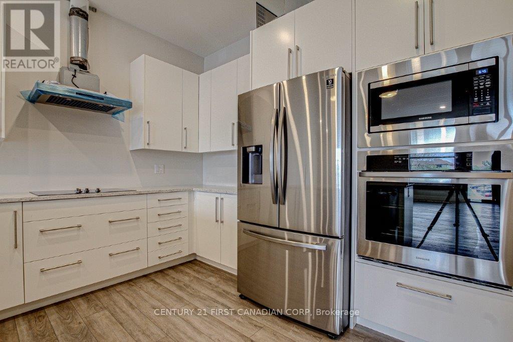 A kitchen with a stainless steel refrigerator and microwave.