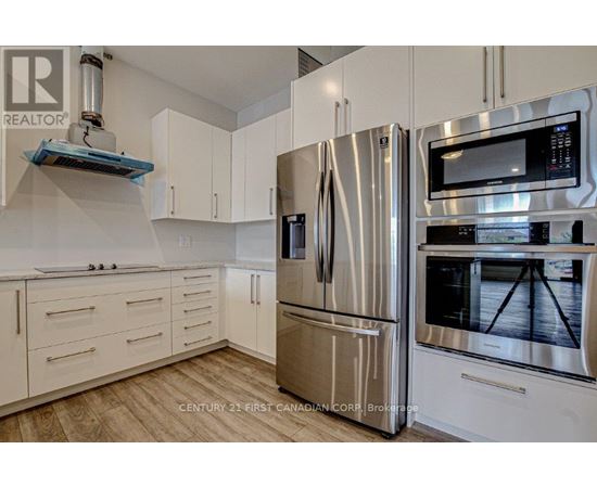 A kitchen with a stainless steel refrigerator and microwave.
