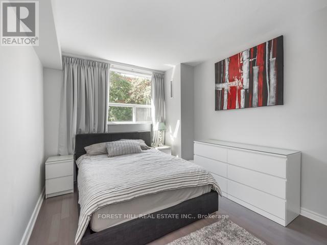 A bedroom with a large bed and a painting on the wall.