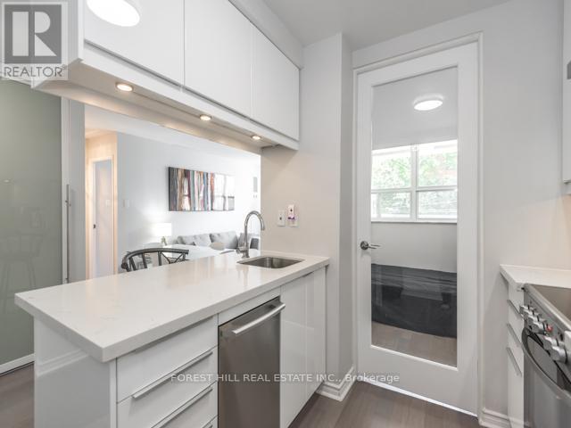 A white kitchen with a sink and a dishwasher.