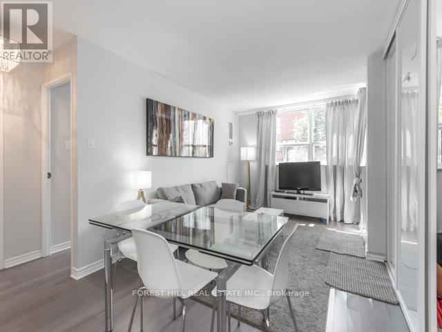 A modern dining room with a glass table and white chairs.