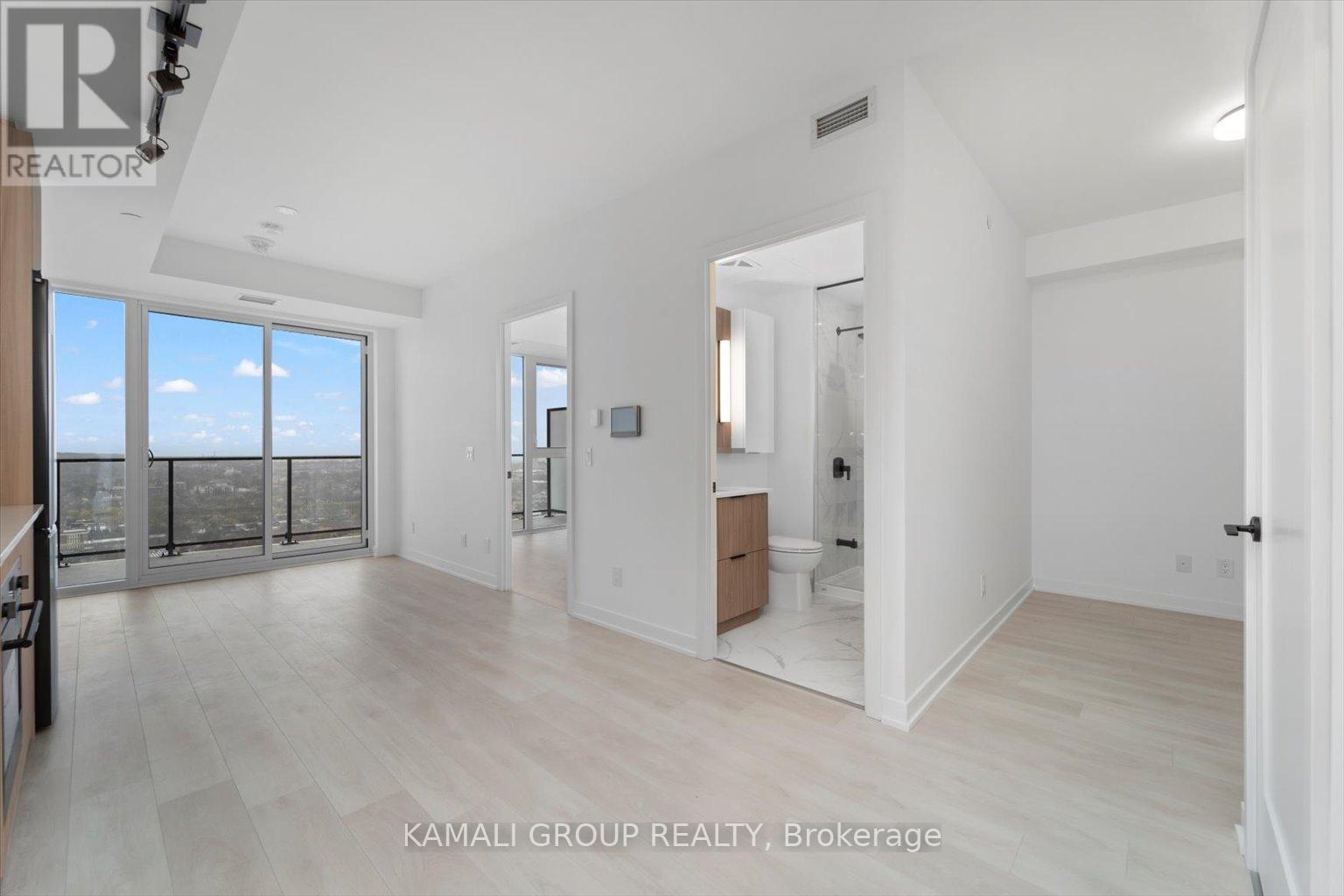 A spacious, well-lit room with a large window and a door leading to another room.