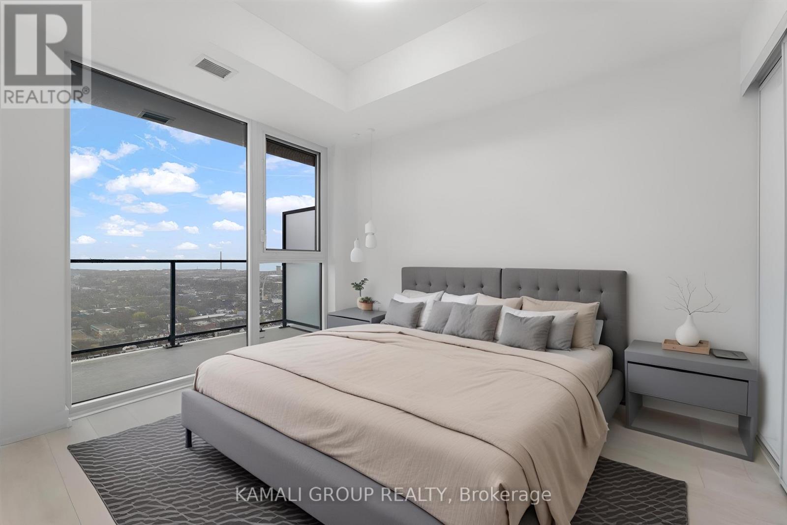 A bedroom with a large bed and a view of the city.