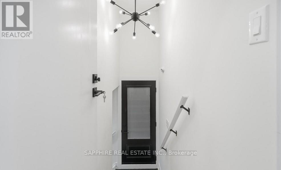 A modern interior with a glass door and a chandelier.