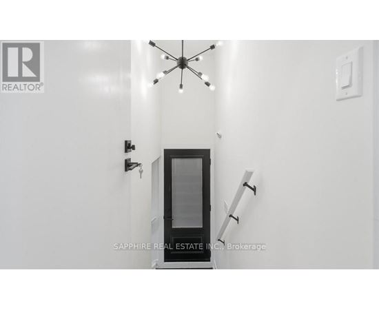 A modern interior with a glass door and a chandelier.