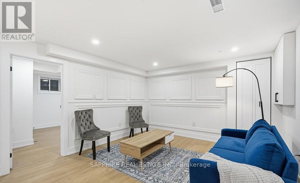 A living room with a white wall and a grey sofa.