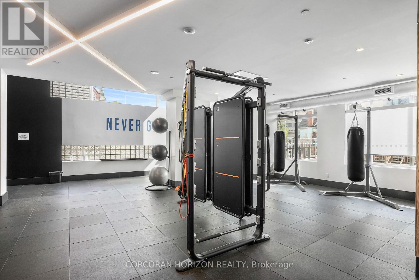 A gym with a squat rack and a wall with the word "NEVER" on it.