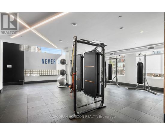 A gym with a squat rack and a wall with the word "NEVER" on it.