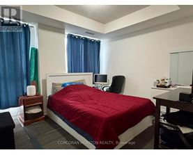 A bedroom with a red bedspread and a white bed.