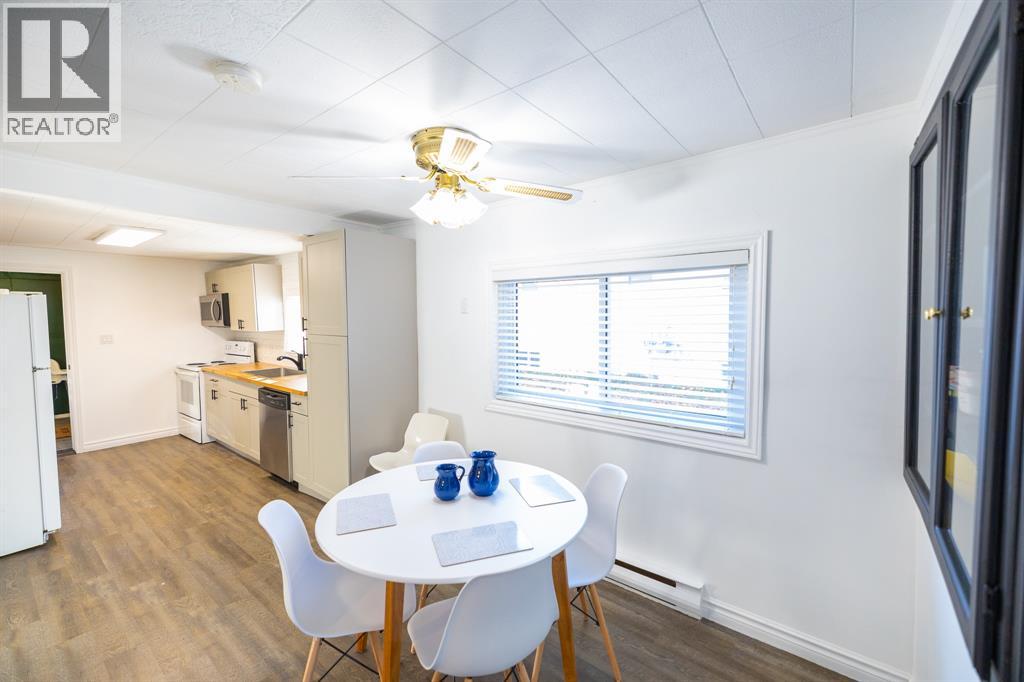 A dining room with a white table and chairs.