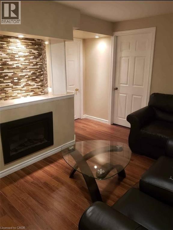 A living room with a fireplace and a glass coffee table.