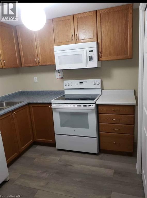 A kitchen with a white oven and microwave above it.