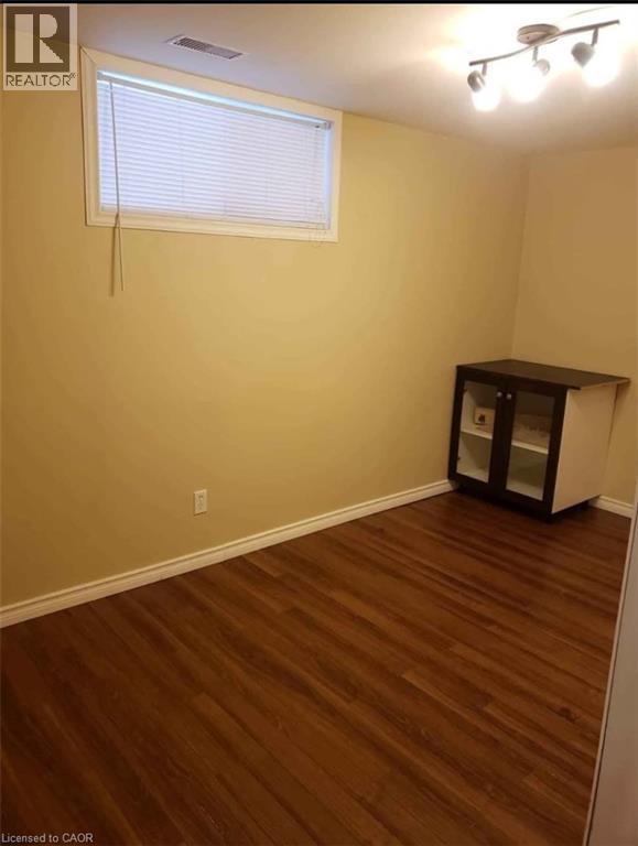 A room with wooden flooring and a window with blinds.