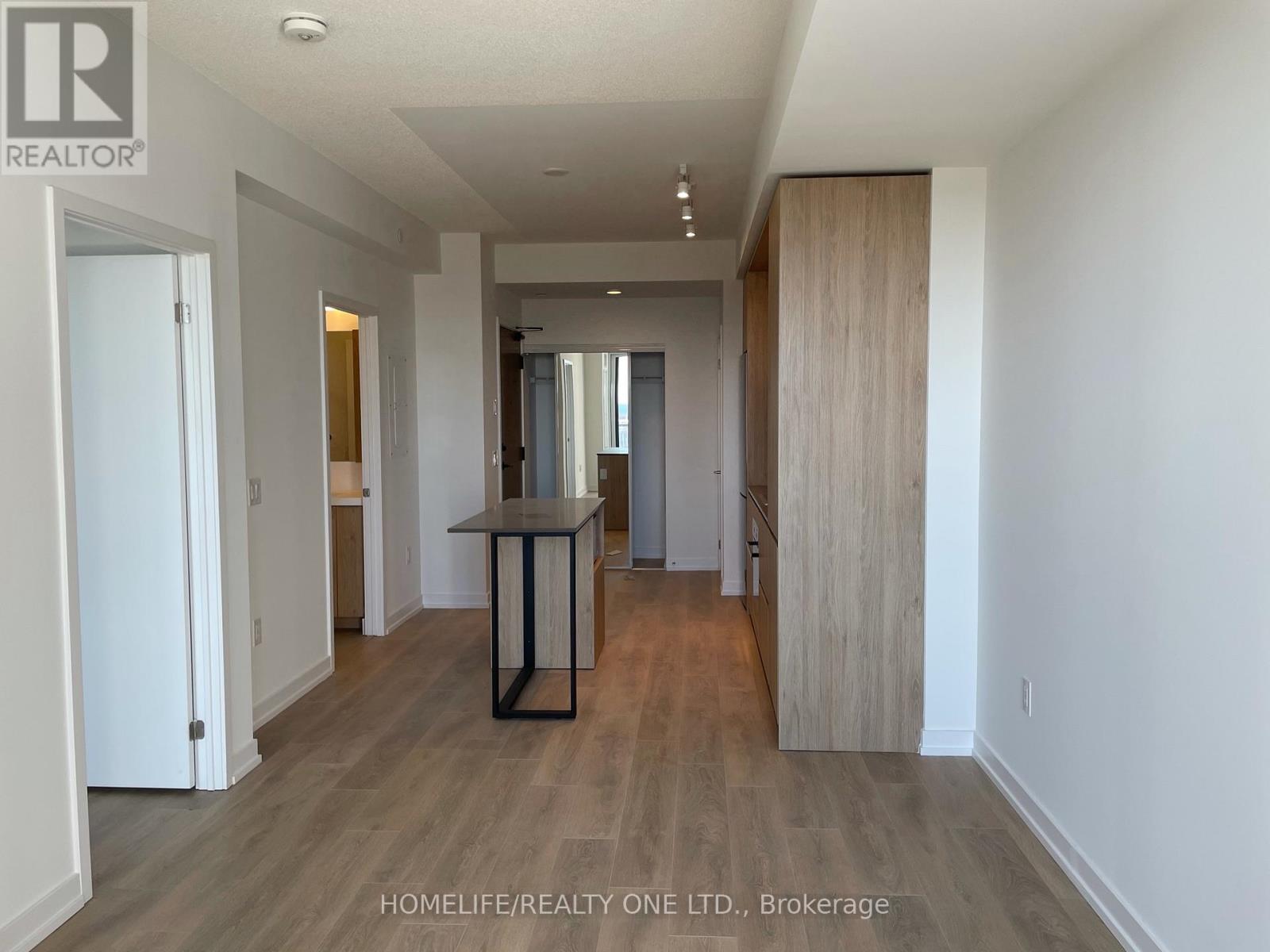 A spacious room with a dining table and chairs in the middle.