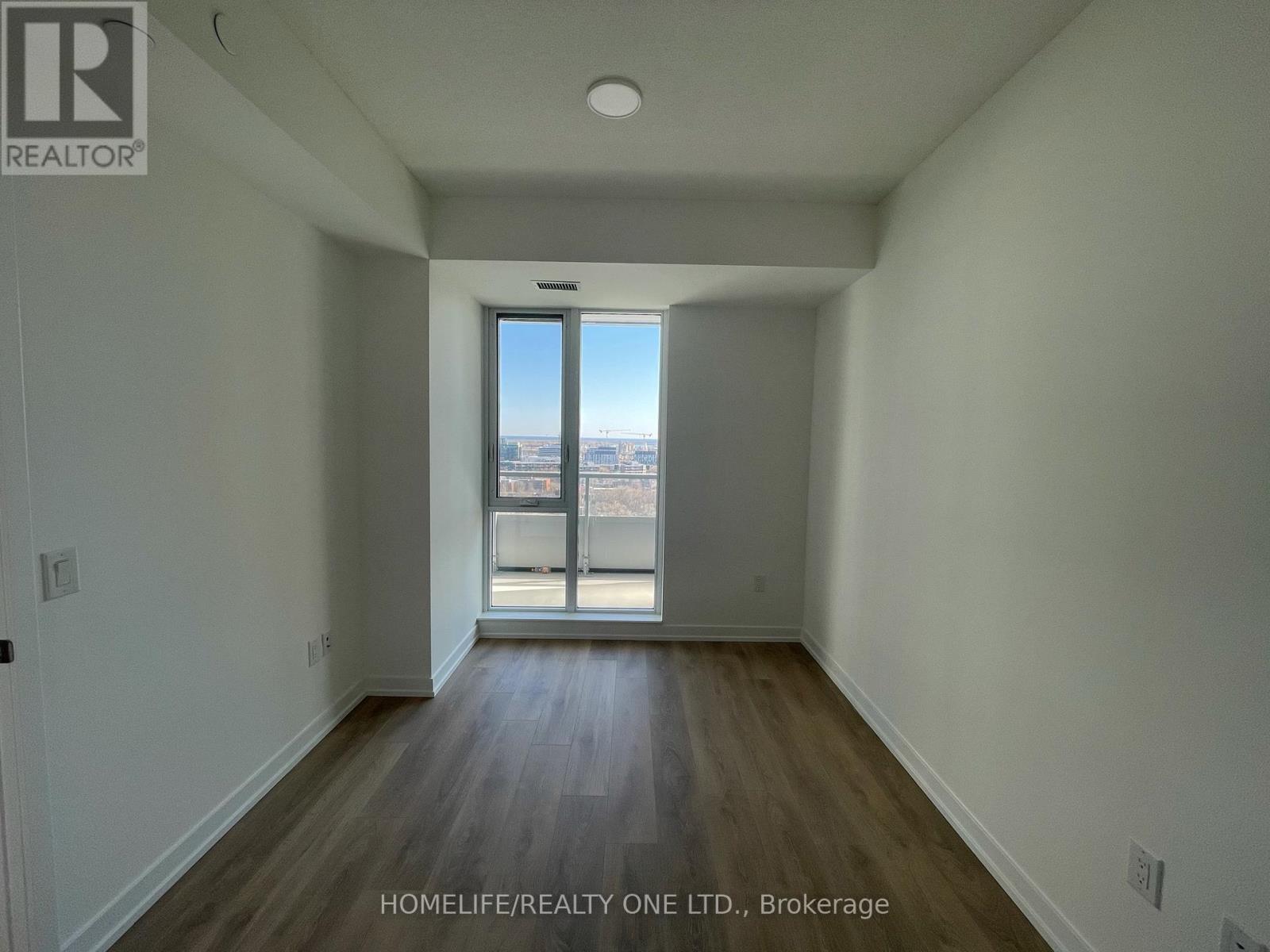 A room with a view of the city through a large window.