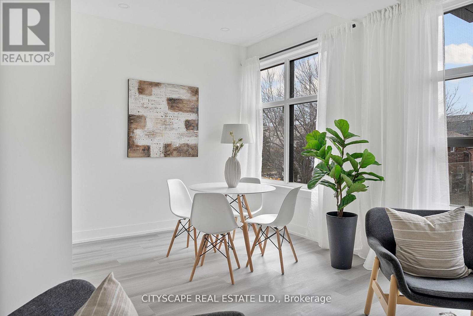 A dining room with a white table and chairs.