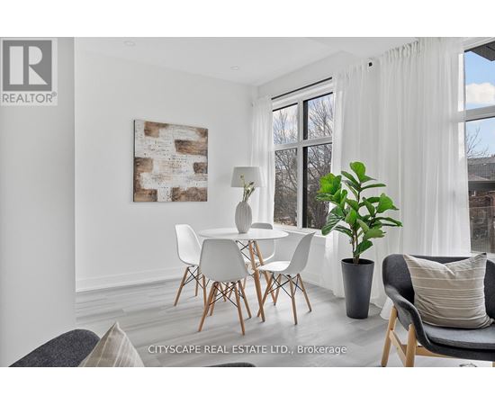 A dining room with a white table and chairs.