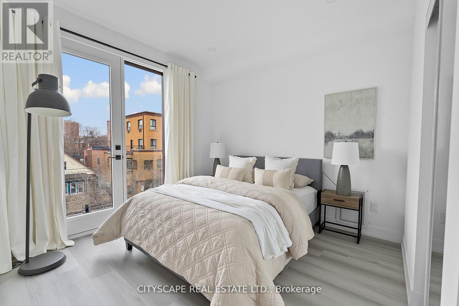A bedroom with a large bed and a view of the city.