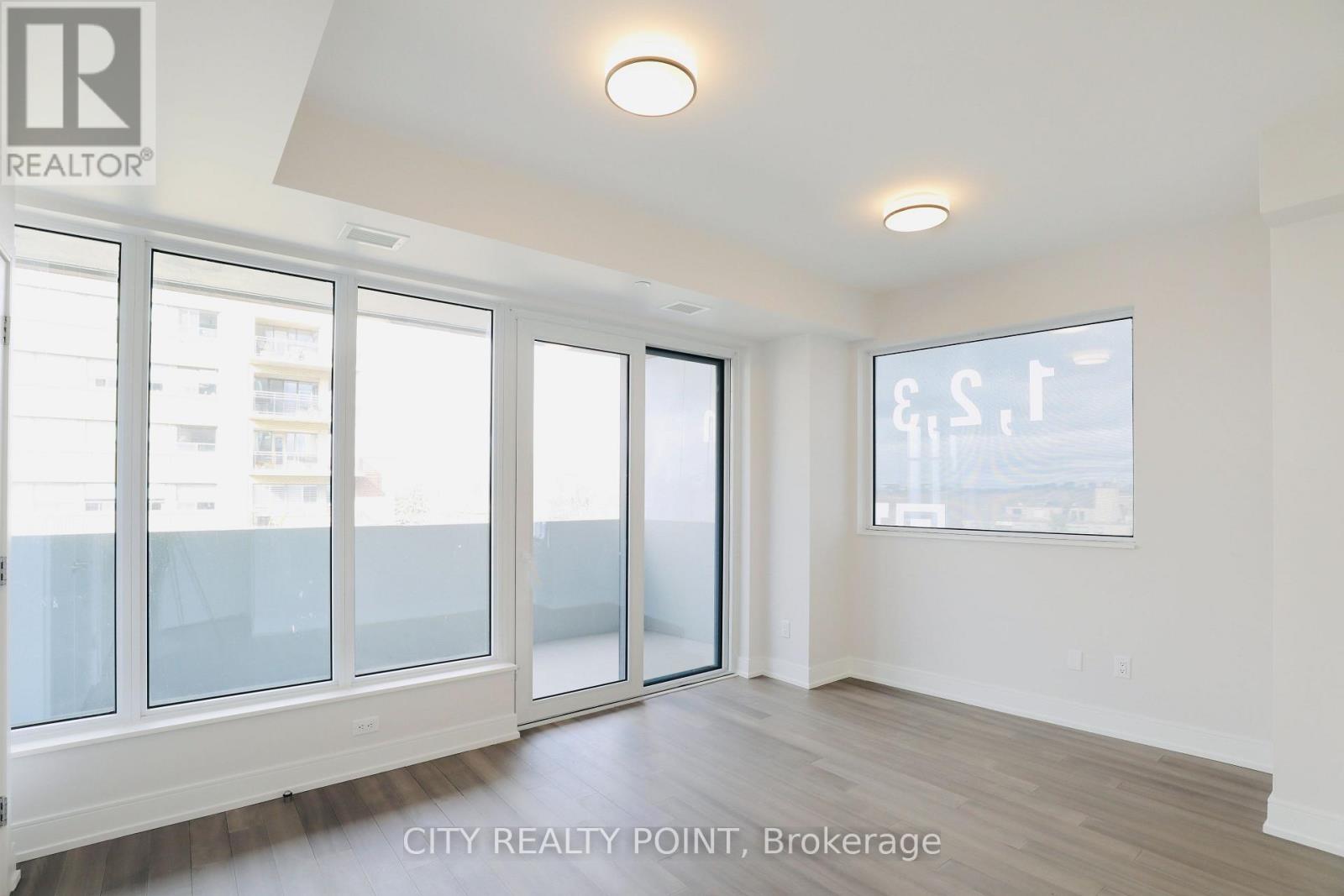 A spacious room with a view of the city through large windows.